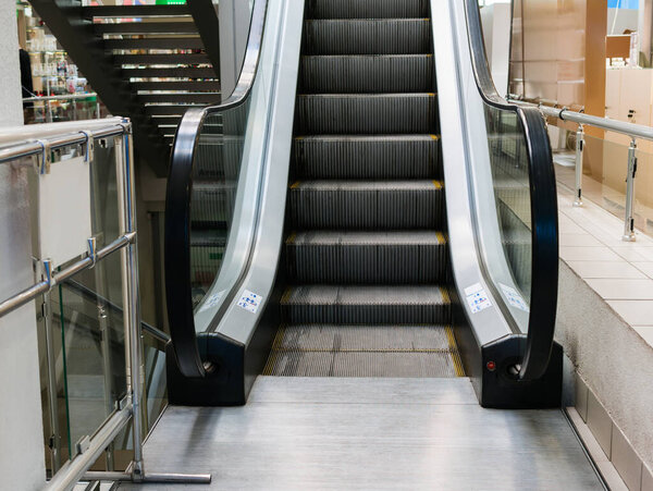 A modern escalator in a shopping center connecting floors and guiding shoppers through the malls bustling interior