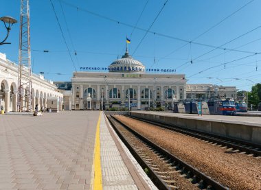 Odesa, Ukrayna - 12 Temmuz 2025: Platformdan Odesa-Holovna tren istasyonu perspektifi, trenler, raylar, yolcular ve gün ışığı altında istasyon binasını ele geçirmek
