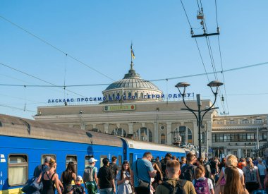 Odesa, Ukrayna - 8 Temmuz 2025: Ukrayna Demiryolları 'nın Odesa-Holovna istasyonuna bavullarıyla gelen yolcular, tarihi istasyon binasının yanındaki platformda yürüyorlar.