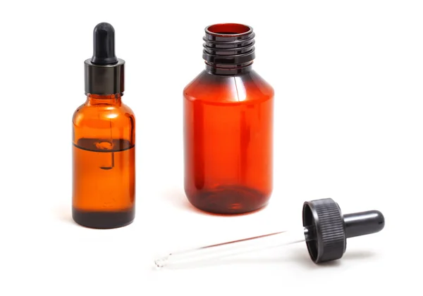 Bir pipet ile turuncu cam şişeler.