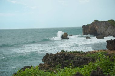 Dramatik Okyanus Dalgaları ve Bulutlu Gök Altında Rocky Sahili
