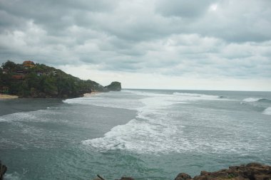 Dramatik Okyanus Dalgaları ve Bulutlu Gök Altında Rocky Sahili
