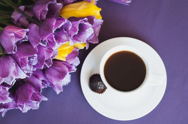 Xícara de café e tulipas roxas — Fotografia de Stock