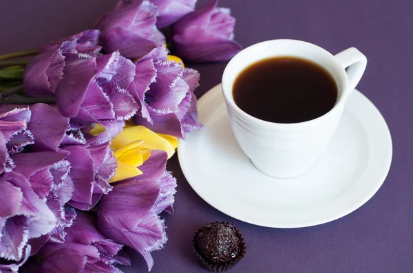 Xícara de café e tulipas roxas — Fotografia de Stock