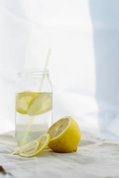 Свежесть концепции, лимонад с ломтиками лимона в банке на белом летнем деревянном фоне — стоковое фото