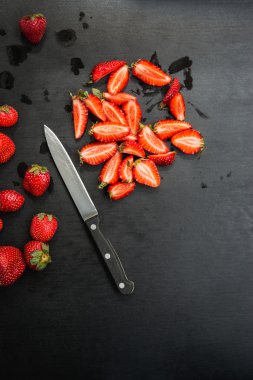 çilek ve siyah arka plan üzerinde bıçak