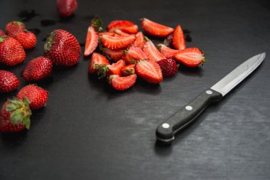 çilek ve siyah arka plan üzerinde bıçak