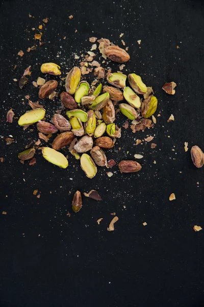 Pistachios on black slate table — Stock Photo, Image