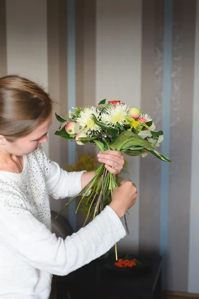 Bloemist maken een boeket van bloemen en takken — Stockfoto