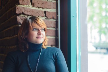 pencere eşiğinde Kızıl saçlı kadın