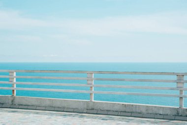 Deniz ve gökyüzü manzaralı eski paslı demir ve ahşap beyaz çit, yatay yaşam tarzı fotoğraf arkaplanı
