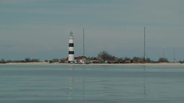 Faro en una orilla arenosa baja — Vídeo de stock