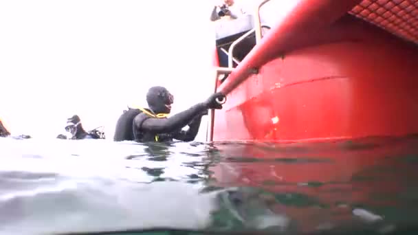 Nurek z wody unosi się w górę do pokładu nurkowania bot. — Wideo stockowe
