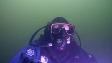 Dalgıç çamurlu su çamurlu zemin üzerinde yüzüyor..