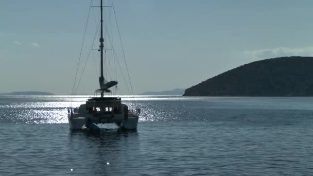 Catamarán de vela en los rayos del sol de la tarde . — Vídeo de stock