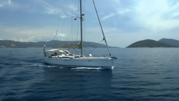 Yacht a vela galleggiante sullo sfondo di montagna lontana . — Video Stock