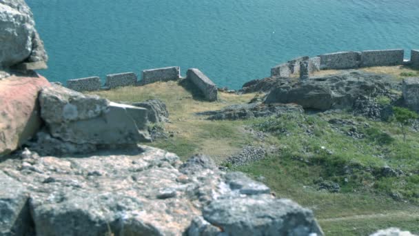 The ruins of the ancient wall against the sea and the Greek city. — Stock Video