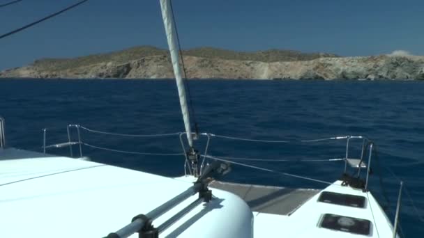 Zeilen-catamaran naar de rotsachtige kust nadert. — Stockvideo