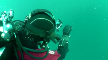 Kolunda monte aygıt (dalış bilgisayarı) bakarak dalgıç.