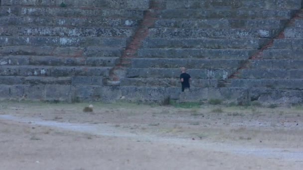 Modern grekisk man joggar i en antik grekisk stadion. — Stockvideo