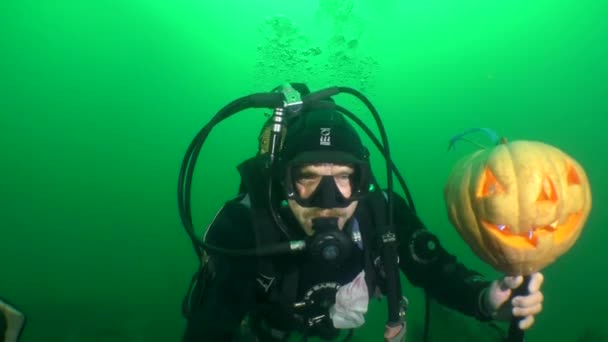 Halloween sous l'eau : Un plongeur avec une citrouille éclatante Halloween. — Video