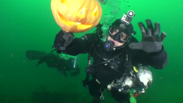 Halloween bajo el agua: Un buceador con una calabaza brillante de Halloween. — Vídeo de stock