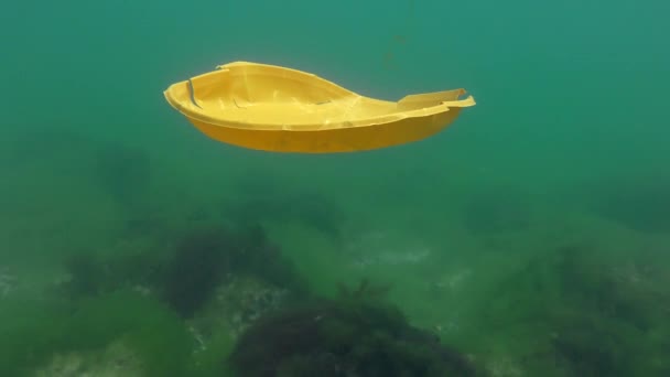 Contaminación plástica del océano: una placa desechable de plástico se hunde lentamente en el fondo del mar. — Vídeo de stock