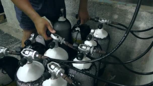 A merülési központ alkalmazottja megtölti a palackokat nagy nyomású levegővel.. — Stock videók