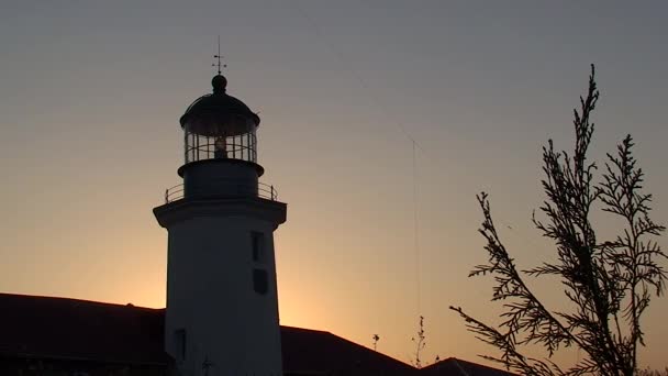 Phare contre le coucher du soleil, plan moyen. — Video