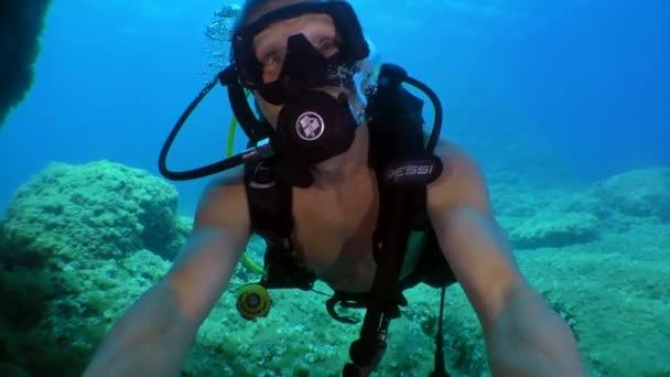 Diver swims into the cave looking around, front view, close-up. — Stock Video