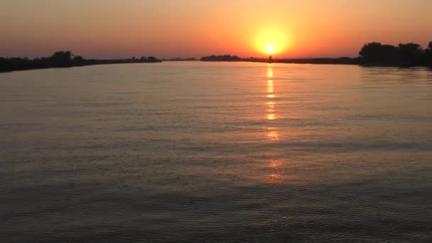 Puesta de sol en el río: un sol bajo se refleja en el agua. — Vídeos de Stock