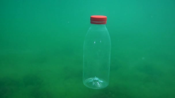 Plastikverschmutzung: PVC-Flasche sinkt langsam auf den Boden. — Stockvideo