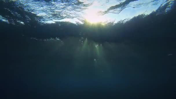 Los rayos del sol penetran la superficie vibratoria del agua, forman destellos de luz en el espesor. — Vídeo de stock