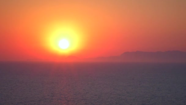 Solnedgång över havet med avlägsna berg vid horisonten. — Stockvideo