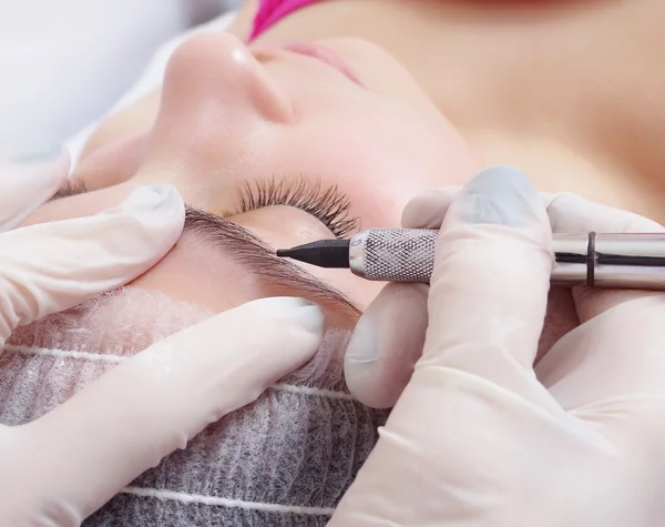 Tattooist is using  gun tool for eyebrows tattoo — Stock Photo, Image