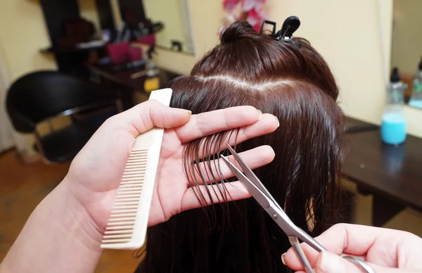 Peluquería está haciendo un corte de pelo para el cliente en un salón — Foto de Stock