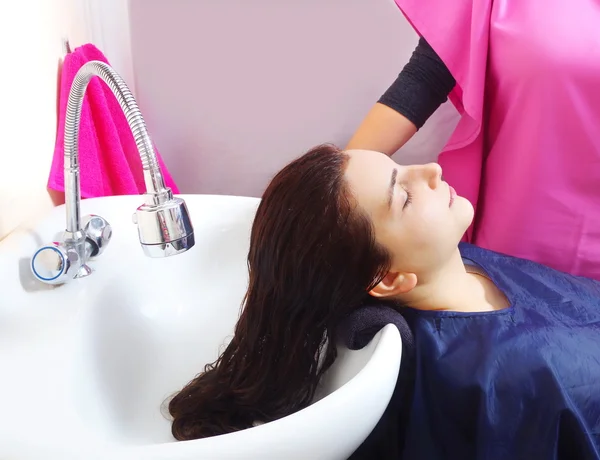 Young beautiful girl is having hairwash in a salon closeup — Stock Photo, Image