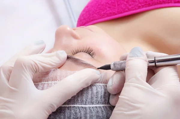 Tattooist is using  gun tool for eyebrows tattoo — Stock Photo, Image