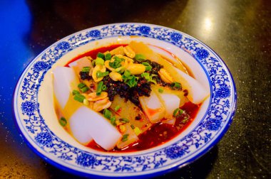 Çin Soğuk Eriştesi Kara Fasulye Sosu, Kızarmış Fıstık ve doğranmış Yeşil Taze Soğanla süslenmiş.