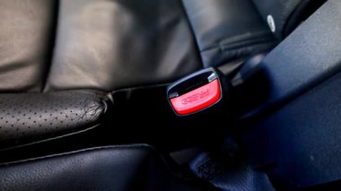 Bir el tokanın içine emniyet kemerini yerleştirir, bir tıklamayla emniyete alır. Bu, yoldaki güvenliğin öneminin bir hatırlatıcısıdır..