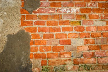 Eski kırmızı tuğlalı bir duvarın desenli bir yüzeyi. Üzerinde gri alçı parçaları ve uzun süreli aşınma izleri var. Karşıt eklemlere sahip düzensiz masonluk özgün bir vintage arkaplan yaratır,