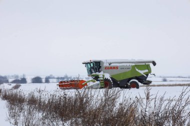 Lviv, Ukrayna - 07 Ocak 2026: Bir Claas Lexion 580 tahıl hasatçısı kış uykusunda karlı bir tarlanın ortasında duruyor..