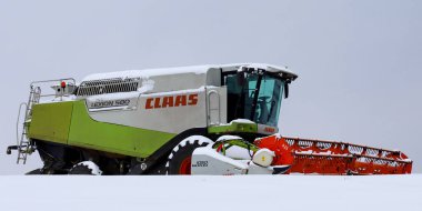 Lviv, Ukrayna - 07 Ocak 2026: Taze kar tabakasıyla kaplı devasa başlık ve operatör taksisi, sert kış koşullarında modern tarım makinelerinin benzersiz bir görüntüsünü oluşturdu.