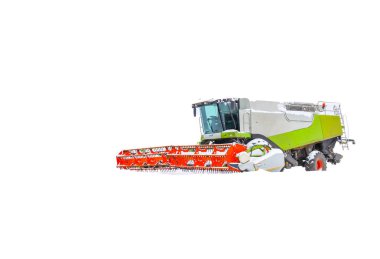 Büyük, modern bir biçerdöver, parlak kırmızı bir başlıkla beyaz, karla kaplı bir tarlanın ortasında duruyor. Güçlü tarım makinesi saf kara karşı izole edilmiştir.,