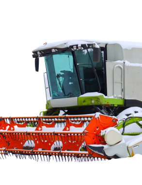 Modern bir tahıl hasatçısının kabin ve portakal başlığı açık beyaz bir gökyüzüne karşı yumuşak karla kaplıdır. Güçlü tarım makineleri kış uykusunda. Bu da her türlü hava koşulunda faaliyete hazır olduğunu gösteriyor..