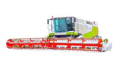 Parlak turuncu başlıklı güçlü bir tarım biçicisi kış tatilinde karlı bir tarlanın ortasında hareketsiz duruyor..