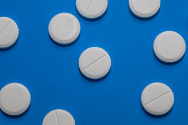 Puan çizgisi olan beyaz yuvarlak haplar mavi arkaplan boyunca rastgele dağılır ve farklı bir renk kontrastı oluşturur..