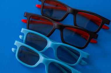 Siyah ve açık mavi çerçeveli dört çift 3D sinema gözlüğü koyu mavi arka planda sıralanmıştır. Geometri ve doymuş renklere odaklanan bu şık kompozisyon modern sinemanın atmosferini mükemmel bir şekilde yakalar.,