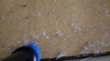 Toz ve enkazı temizlemek için kanepenin ahşap altını iyice süpürüyorum. Kontrplak mobilyaları modern bir süpürge fırçası kullanarak temizleme işlemi.