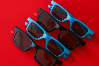 Dört çift siyah ve mavi 3D gözlük parlak kırmızı arka planda köşegenler halinde serilmiştir. Ritmik kompozisyon ve zıt gölgeler kollektif filmi sembolize eden şık bir görsel görüntü yaratır.